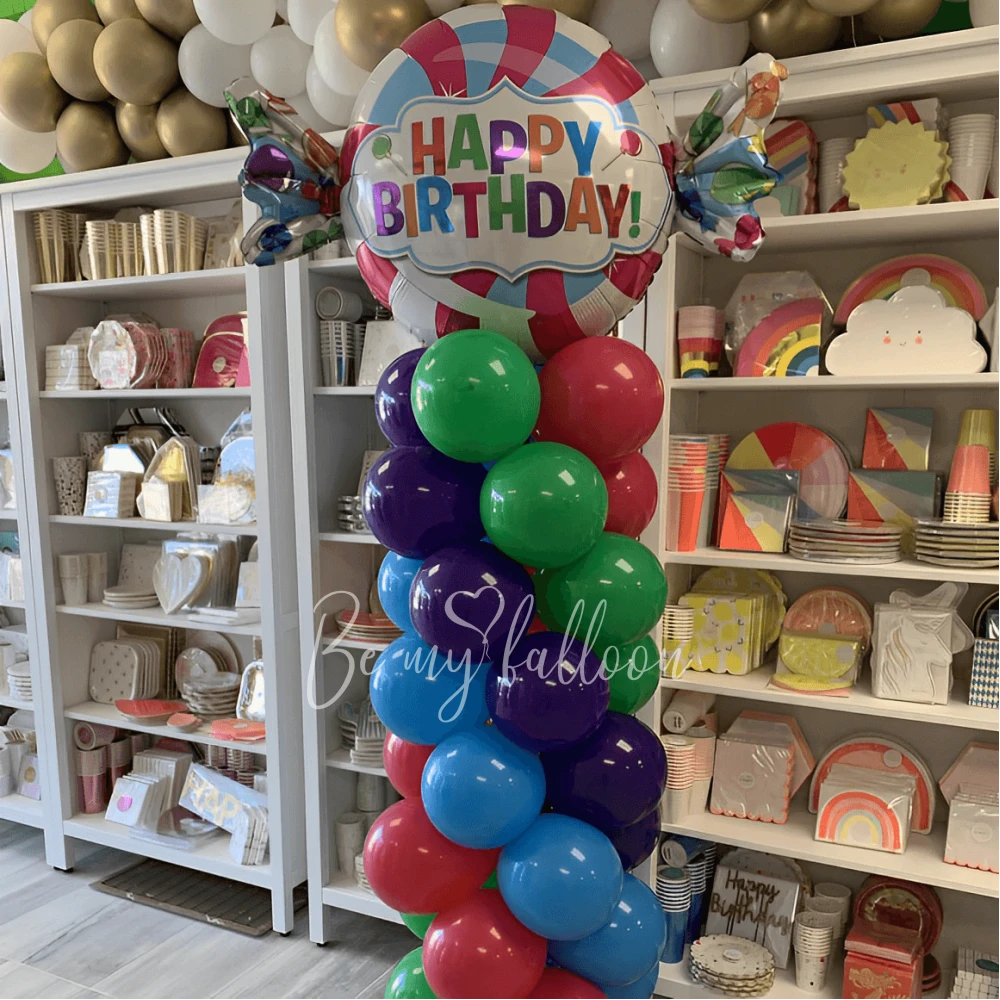 Multicolour pillar with a Candy Happy Birthday balloon composition
